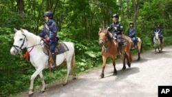 Polisi berkuda mencari anak laki-laki berusia tujuh tahun yang menghilang di sebuah hutan di kota Nanae, pulau Hokkaido, Jepang (30/5). 