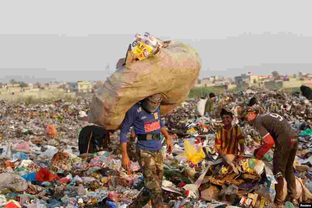 이라크 바그다드 외곽의 쓰레기 집하장에서 재활용품을 골라 모으고 있는 사람들.