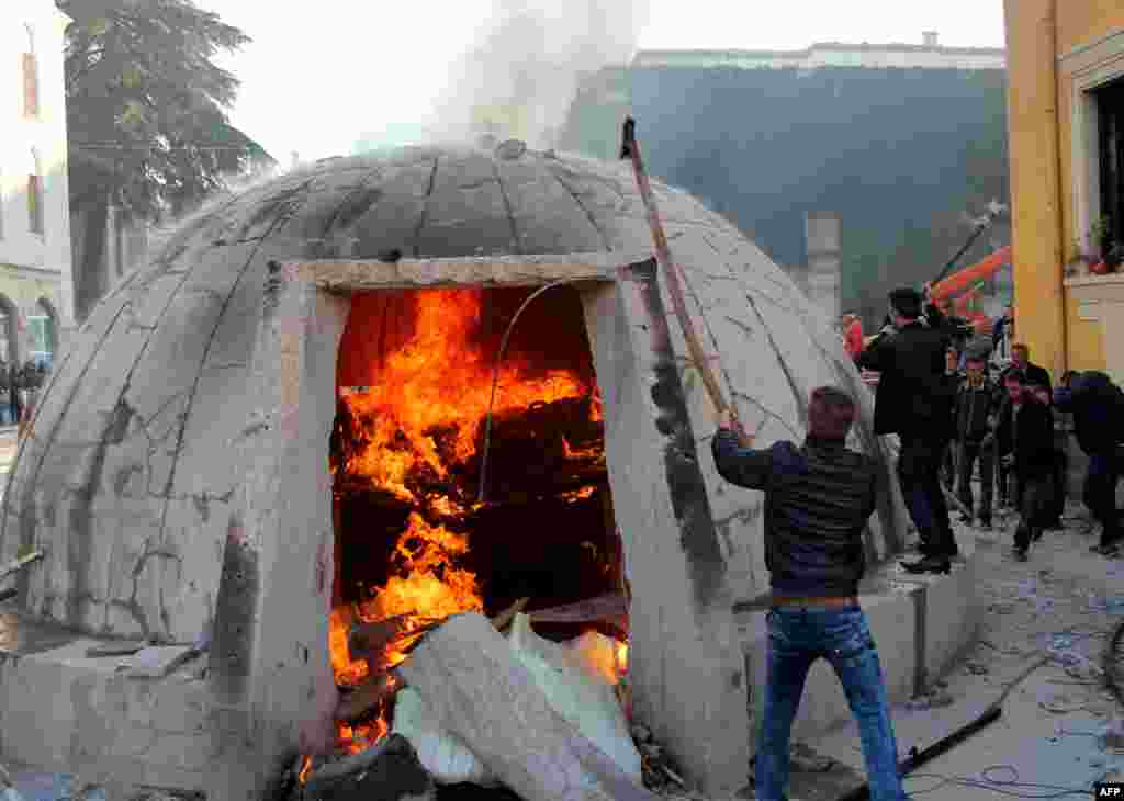 Protesters destroy a bunker installed as an artwork near the Interior Ministry during a rally organized by the opposition Democratic Party to demand the resignation of the government, in Tirana on the day that marks the 25th anniversary of the student protests that led to the toppling of the last communist regime in Europe in 1990.