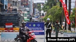 Sejumlah tentara menjaga titik penyekatan PPKM darurat untuk meredam penyebaran pandemi COVID-19 di Medan, Sumatera Utara, Kamis, 15 Juli 2021. (Foto: Binsar Bakkara/AP)