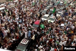 Supporters of former Pakistani Prime Minister Nawaz Sharif crowd around his car as his convoy enters Rawalpindi, Aug. 9, 2017.