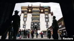 FILE - Pilgrims and tourists visit Potala Palace in Lhasa in Tibet Autonomous Region.
