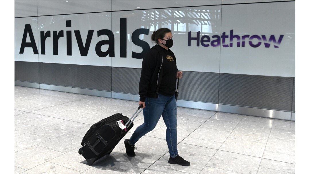 Seorang penumpang mengenakan masker tiba di bandara Heathrow, London barat, Inggris, di tengah pandemi Covid-19,10 Juli 2020