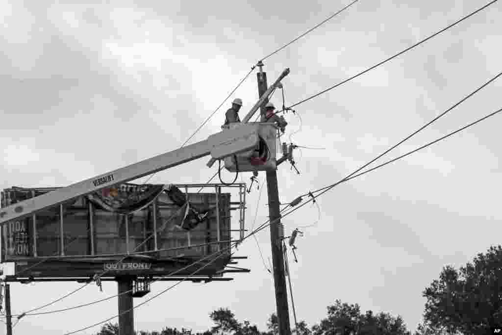 Power company workers repair damaged power lines damages from Hurricane Harvey, in Katy, Texas, Aug. 26, 2017.