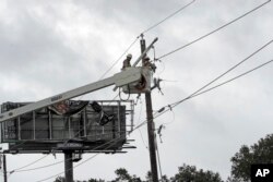 Power company workers repair damaged power lines damages from Hurricane Harvey, in Katy, Texas, Aug. 26, 2017.
