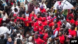 FILE - Musician turned politician Robert Kyagulanyi, center, is joined by other activists during a demonstration to protest a controversial tax on the use of social media, in Kampala, Uganda, July 11, 2018.