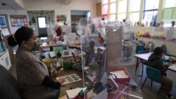 FILE - In this March 18, 2021, file photo, surrounded by protective shields, pre-kindergarten teacher Tami Lewis teaches her class at West Orange Elementary School in Orange, California.