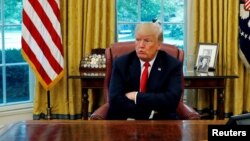 U.S. President Trump reacts to a question during interview with Reuters in the Oval Office of the White...