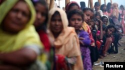 Rohingya refugees line up to receive humanitarian aid in Balukhali refugee camp near Cox's Bazar, Bangladesh, Oct. 26, 2017. 
