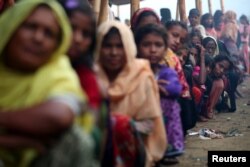FILE - Rohingya refugees line up to receive humanitarian aid in Balukhali refugee camp near Cox's Bazar, Bangladesh, Oct. 26, 2017.