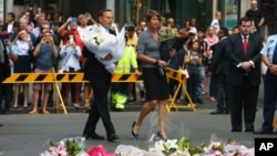 El primer ministro, Tony Abbott, y su esposa, Margie, llevan flores al lugar en Martin Place donde se dio la toma de rehenes en el centro de Sidney, Australia.