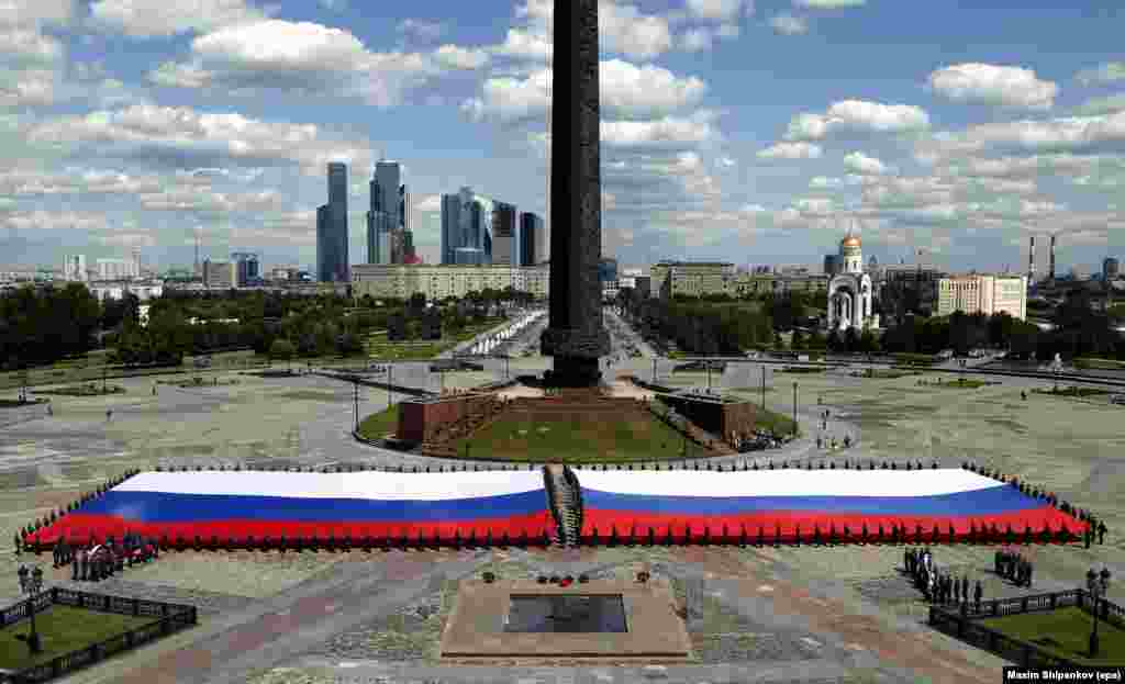 Những học viên của trường trung học thuộc Bộ Khẩn cấp của Nga cầm quốc kỳ Nga được nói là lớn nhất, tại đồi Poklonnaya, đánh dấu &#39;Ngày Nước Nga&#39; sắp tới, ở Moscow.