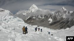 FILE - Mountaineers walk near Camp One of Mount Everest, April 29, 2018, as they prepare to ascend on the south face from Nepal.