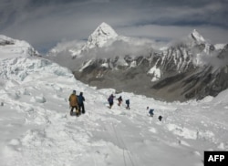 FILE - Mountaineers walk near Camp One of Mount Everest, April 29, 2018, as they prepare to ascend on the south face from Nepal.
