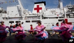 FILE - Venezuelan dancers welcome the arrival of Chinese navy hospital ship " The Peace Ark" docked at the port in la Guaira, Venezuela, Saturday, Sept. 22, 2018.