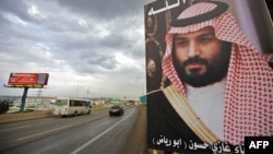 FILE - A poster of Saudi Arabia's Crown Prince Mohammed bin Salman with a phrase reading in Arabic, " God protect you" is seen on a highway in the northern Lebanese port city of Tripoli, Nov. 9, 2017.