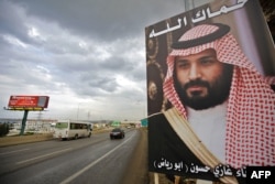 FILE - A poster of Saudi Arabia's Crown Prince Mohammed bin Salman with a phrase reading in Arabic, " God protect you" is seen on a highway in the northern Lebanese port city of Tripoli, Nov. 9, 2017.