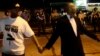 Civilian peacekeepers join hands to separate demonstrators protesting against the shooting of Michael Brown away from the police in Ferguson, Missouri, Aug. 19, 2014. 