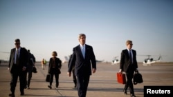 U.S. Secretary of State John Kerry, second from right, walks across the tarmac of Baghdad International Airport as he prepares to board an aircraft out of the Iraqi capital, Mar. 24, 2013.