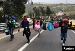 Venezuelan migrants walk along the Ecuadorean highway to Peru before new rules requiring they hold a valid passport kick in, at Tulcan, Ecuador, Aug. 21, 2018.