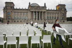 Aktivis menata kursi di 'Platz der Republik' di depan gedung Reichstag, di Berlin, Jerman, sebagai bagian dari hari aksi anti-rasis nasional, Senin, 7 September 2020.