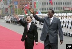 FILE - Taiwan's then-president, Chen Shui-bian, left, and Blaise Compaoré, who was then president of Burkina Faso, wave to well-wishers during an honor guard review, Nov. 20, 2006, in front of the Presidential Office in Taipei, Taiwan. Burkina Faso has now severed those formal ties. Today, fewer than 20 nations recognize Taiwan's independence.