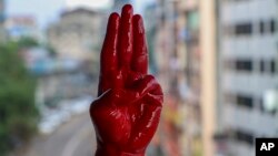 Một người biểu tình giơ bàn tay sơn màu đỏ với 3 ngón tay biểu tượng của phong trào biểu tình chống đảo chính ở Myanmar, để tưởng niệm những người đã bị giết chết trong các cuộc biểu tình ở Yangon, Myanmar, ngày 6/4/2021. (AP Photo)