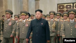ຜູ້ນຳເກົາຫຼີເໜືອ Kim Jong Un ພ້ອມກັບທະຫານບໍລິວານ ຢ້ຽມຢາມ ພະລາດຊະວັງ Kumsusan ເພື່ອຄຳນັບຜູ້ສ້າງຕັ້ງ ມື້ລາງປະທານປະເທດ Kim Il Sung ແລະ ອະດີດຜູ້ນຳ Kim Jong Il ອັນເປັນຂີດໝາຍ ຄົບຮອບ 61 ປີ ຂອງໄຊຊະນະ ສົງຄາມປົດປ່ອຍປິຕຸພູມ ຢູ່ນະຄອນຫລວງ Pyonghyang, ວັນທີ 27 ກໍລະກົດ 2014.