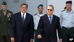Israel's Defense Minister Ehud Barak (R) walks with U.S. Secretary of Defence Leon Panetta during an official guard of honor ceremony at the Kirya base in Tel Aviv October 3, 2011.