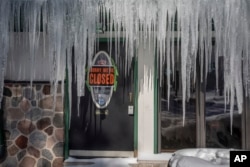 Icicles hang in front of a door at a bar in Mequon, Wisconsin, Jan. 30, 2019 as temperatures were subzero and wind chills were at -50 degrees F.