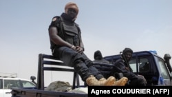 Des policiers maliens dans un véhicule à Anderamboukane, dans la région de Menaka, le 22 mars 2019.