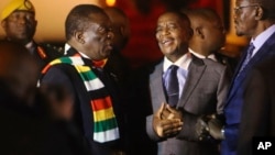 Zimbabwean President Emmerson Mnangagwa, left, arrives at Robert Mugabe International Airport in Harare, Zimbabwe, Monday, Jan. 21, 2019.