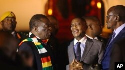 Zimbabwean President Emmerson Mnangagwa, left, arrives at Robert Mugabe International Airport in Harare, Zimbabwe, Monday, Jan. 21, 2019.