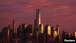 FILE - The setting sun reflects off of One World Trade Center and surrounding buildings at sunset in the Manhattan borough of New York City, Nov. 22, 2015. 