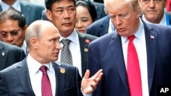 FILE - U.S. President Donald Trump, right, and Russia's President Vladimir Putin talk during the family photo session at the APEC Summit in Danang, Nov. 11, 2017. 