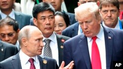 U.S. President Donald Trump, right, and Russia's President Vladimir Putin talk during the family photo session at the APEC Summit in Danang, Nov. 11, 2017. 