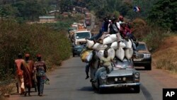 A vehicle filled with people and heavy load, precedes a convoy of over 100 trucks arriving in the Central African Republic capital Bangui from Cameroon, Monday Jan. 27, 2014. The trucks were loaded with military logistic for French forces and Humanitarian