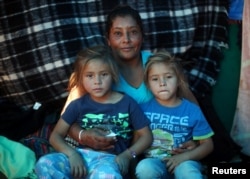Maria Lila Meza, a 39-year-old migrant woman from Honduras, part of a caravan of thousands from Central America trying to reach the U.S., sits with her five-year-old twin daughters Cheili Nalleli Mejia Meza and Saira Nalleli Mejia Meza inside their tent in Tijuana, Nov. 26, 2018.