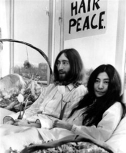 John Lennon and Yoko Ono holding a "bed-in" in Amsterdam on March 25, 1969. They were protesting the US war in Vietnam.