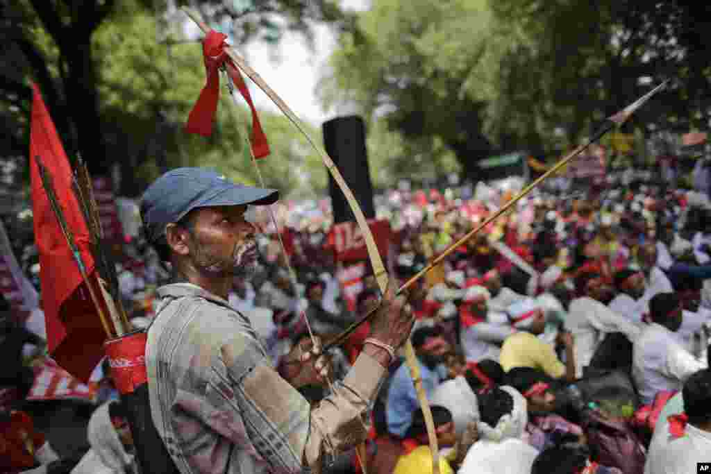 An Indian farmer holds a bow and an arrow as he attends a gathering near parliament for a protest against the Land Acquisition Bill, in New Delhi. Farmers protested against the ruling Bharatiya Janata Party&rsquo;s bill, calling it anti-farmer in a country where agriculture is the main livelihood for more than 60 percent of the 1.2 billion people.
