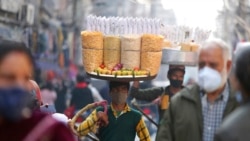 A snacks vendor wears a face mask as a precaution against COVID-19 in a market area in Jammu, India, Nov. 27, 2021.