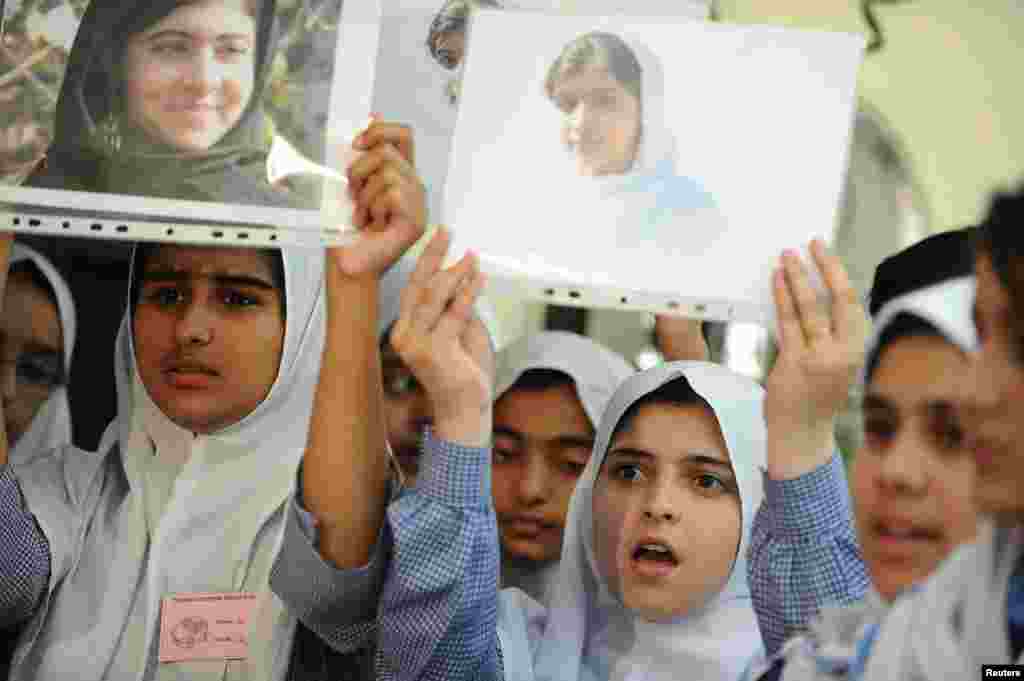 Para siswa di Abu Dhabi memegang foto-foto Malala Yousafzai dalam penghormatan untuknya di Kedutaan Besar Pakistan (15/10).