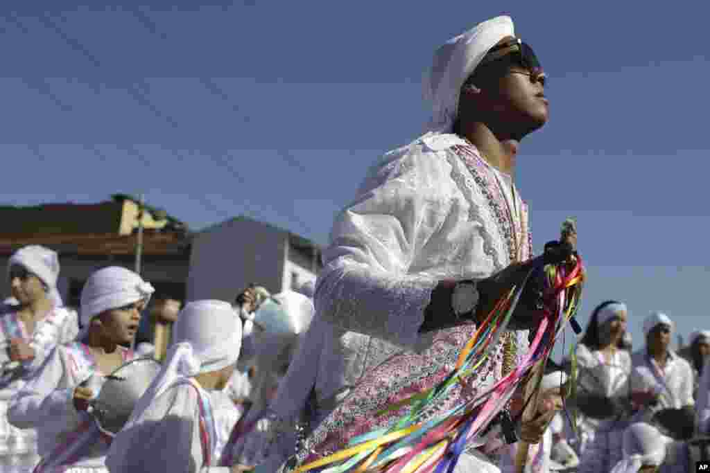 Matheus Alves, captain of the Mozambique Our Lady of the Rosary dance group, performs during the annual Afro-Christian Congada celebration in Catalao, Goias state, Brazil, Oct. 9, 2016. His turban is the signature of Mozambique dance group, as they pay tr