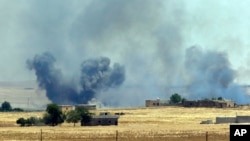 FILE - Smoke from a U.S.-led airstrike rises over the outskirts of Tal Abyad, Syria, in this photo taken in Akcakale, Sanliurfa province, southeastern Turkey from the Turkish side of the border between Turkey and Syria, June 14, 2015.