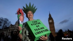 Seorang pengunjuk rasa yang berkostum a la Patung Liberty mengambil bagian dalam unjuk rasa menentang Presiden Donald Trump di London, Inggri 20 Februari 2017 (foto: REUTERS/Toby Melville)