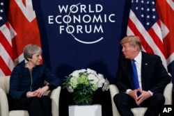 FILE - U.S. President Donald Trump meets with British Prime Minister Theresa May at the World Economic Forum in Davos, Switzerland, Jan. 25, 2018. Neither will attend this year.