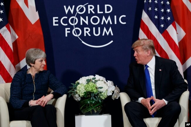 FILE - U.S. President Donald Trump meets with British Prime Minister Theresa May at the World Economic Forum in Davos, Switzerland, Jan. 25, 2018. Neither will attend this year.