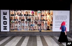 A woman walks by an advertising for diversity and tolerance in the window of shopping mall in Stockholm, Sweden, Aug. 31, 2018.