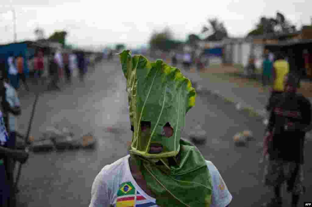 A protester wears a mask made from a leaf in the Cibitoke neighborhood of Bujumbura, Burundi. Protesters dismissed a constitutional court ruling that cleared President Pierre Nkurunziza to run for a controversial third term, as the government offered to release activists if deadly demonstrations stopped.