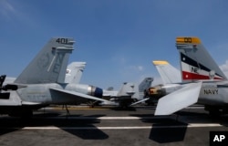 U.S. military aircraft sit on the flight deck of the USS Carl Vinson aircraft carrier anchored off Manila, Philippines, Feb. 17, 2018. Lt. Cmdr. Tim Hawkins said American forces will continue to patrol the South China Sea wherever international law allows.
